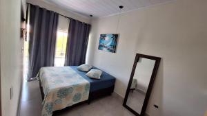 a small bedroom with a bed and a mirror at Flat LITORAL SUL PB CARAPIBUS in Conde +16 photos