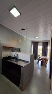 a kitchen with a sink and a counter in a room at Flat LITORAL SUL PB CARAPIBUS in Conde