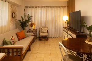 波拉马尔Apartamento Vacacional Costa Azul con salida Directa a la Playa Isla Margarita的带沙发、电视和桌子的客厅