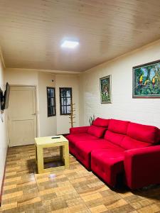 ein Wohnzimmer mit einem roten Sofa und einem Tisch in der Unterkunft Casa de huéspedes in Puerto Iguazú + 18 Fotos