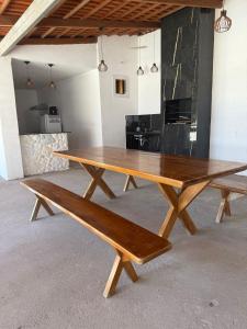 un tavolo in legno e una panca in una stanza di Rancho da Serra a Lagoa Nova