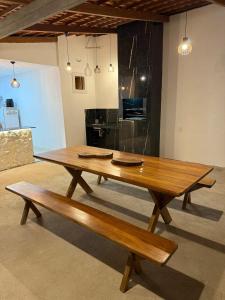 un tavolo in legno e panche in una stanza di Rancho da Serra a Lagoa Nova