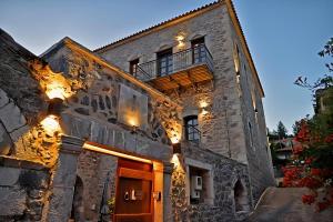 a large stone building with lights on it at Archontiko Leontari in Leondari