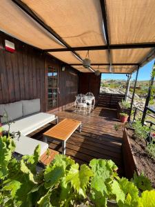 una terrazza in legno con divano e tavolo di Granja Penitente a Minas