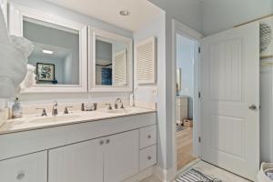 ein weißes Badezimmer mit Waschbecken und Spiegel in der Unterkunft TP4937: 4937 Turtle Point in Kiawah Island + 29 Fotos