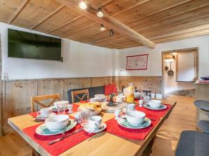 una sala da pranzo con tavolo in legno con piatti e tazze di Zur Alten Schmiede a Wildschönau