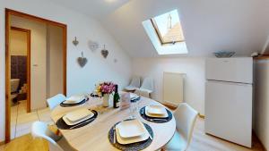 a dining room table with white chairs and a white refrigerator at Au pied du Haut Koenigsbourg 2 in Saint-Hippolyte +21 photos