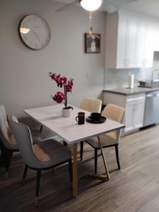 a dining room table with chairs and a table with flowers on it at Cozy 2bdr Beach home in Huntington Beach