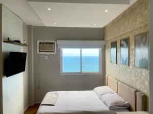 a bedroom with a bed and a window at Porto Real Resort Apto luxo de frente ao mar in Mangaratiba