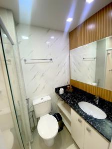 a bathroom with a toilet and a sink and a mirror at Porto Real Resort Apto luxo de frente ao mar in Mangaratiba