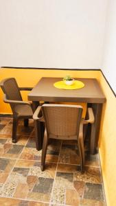 BuenavistaKira Apartahotel的一张桌子，两把椅子，上面放着一个黄色盘子。