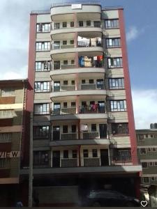 a tall apartment building with people on the balconies at Studios in roysambu in Nairobi