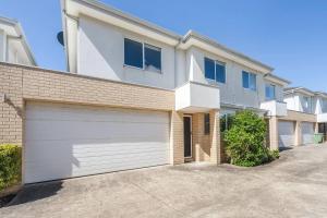 een groot wit huis met een garage bij Foreshore Escape - Beachside Comfort near Dining in Safety Beach