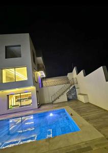 una piscina frente a una casa por la noche en Chalet restinga smir, en M'diq