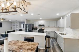 cocina abierta con armarios blancos y mesa en Your Serene Escape in Schertz San Antonio and NB, en Schertz