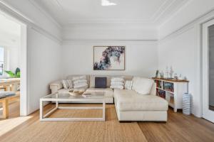 a living room with a couch and a table at Blu Ocean Views Collaroy - Sunroom & BBQ in Collaroy