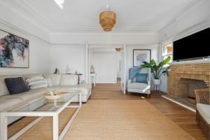 a living room with a couch and a fireplace at Blu Ocean Views Collaroy - Sunroom & BBQ in Collaroy