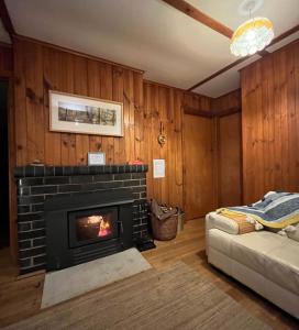 a living room with a fireplace and a couch at Nunyara - BYO Linen in Aireys Inlet