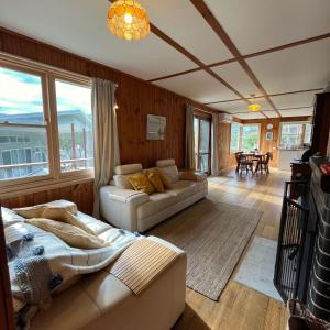 a living room with two couches and a table at Nunyara - BYO Linen in Aireys Inlet