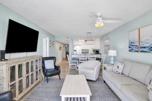 a living room with a couch and a flat screen tv at Buena Vista 102 in Gulf Shores