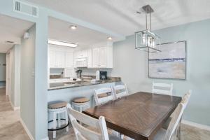 a kitchen and dining room with a wooden table and chairs at Buena Vista 102 in Gulf Shores
