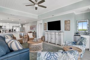 a living room with a blue couch and a tv at The Wharf 701 in Orange Beach