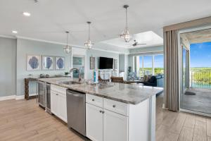 a kitchen with a large counter and a living room at The Wharf 701 in Orange Beach