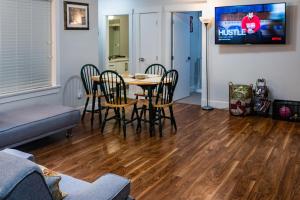 2 bed Suburban Oasis in Surrey في سوري: غرفة معيشة مع طاولة وكراسي وتلفزيون