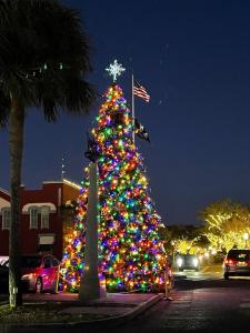 Un árbol de Navidad está iluminado en un estacionamiento. en Golf Cart to Beach , Pet Friendly, Fenced, Quiet, en Fernandina Beach