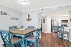 a kitchen and dining room with a blue table and chairs at Phoenix III 3038 in Orange Beach