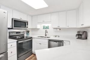 a white kitchen with white cabinets and a sink at Phoenix III 3038 in Orange Beach