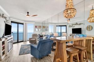 a living room with a dining room table with a view of the ocean at Phoenix East II 2154 in Orange Beach