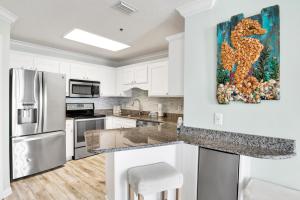 a kitchen with white cabinets and a painting on the wall at Phoenix East II 2154 in Orange Beach