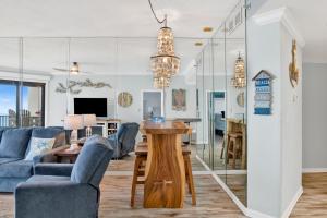 a living room with a blue couch and a table at Phoenix East II 2154 in Orange Beach