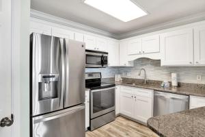 a kitchen with white cabinets and a stainless steel refrigerator at Phoenix East II 2154 in Orange Beach