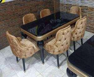 a dining room table with chairs and a black table at Gambie in Kaolack