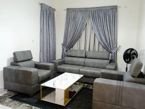 ein Wohnzimmer mit Sofa und Tisch in der Unterkunft Royal Comfort Lodge in Thiès