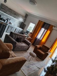 ein Wohnzimmer mit zwei Sofas und einem Tisch in der Unterkunft Royal Comfort Lodge in Thiès