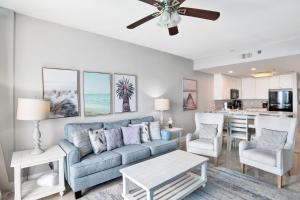 a living room with a blue couch and a kitchen at Lighthouse 1713 in Gulf Shores