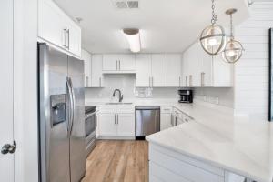 a kitchen with white cabinets and a stainless steel refrigerator at Phoenix X 1201 in Perdido Key