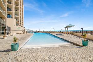 a swimming pool with two potted plants next to a building at Phoenix X 1201 in Perdido Key