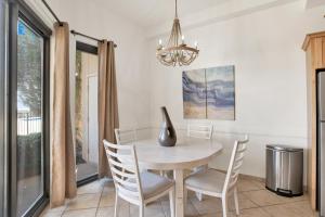 a dining room with a table and chairs and a chandelier at Phoenix V 014 in Orange Beach