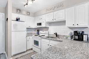 a white kitchen with white cabinets and appliances at Lei Lani M119 in Orange Beach