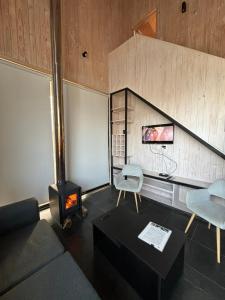 Una sala de estar con un sofá y una estufa. en Cabañas Polikén, en Lago Vichuquen