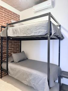 a bunk bed in a room with a brick wall at Casa Xolo Coco in Brisas de Zicatela +59 photos