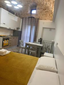 La Castellana في مونتي سانت أنجلو: غرفة بسرير ومطبخ مع طاولة +صورتان