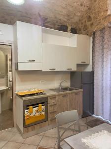 La Castellana في مونتي سانت أنجلو: مطبخ بدولاب بيضاء ومغسلة وموقد