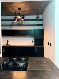 a kitchen with a stove top and a sink at Casa Xolo Coco in Brisas de Zicatela