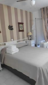 a white bed in a room with a striped wall at Relax Beach in Benalmádena +34 photos