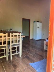 a kitchen and dining room with a table and a refrigerator at Cabañas la flor in Puerto Piray